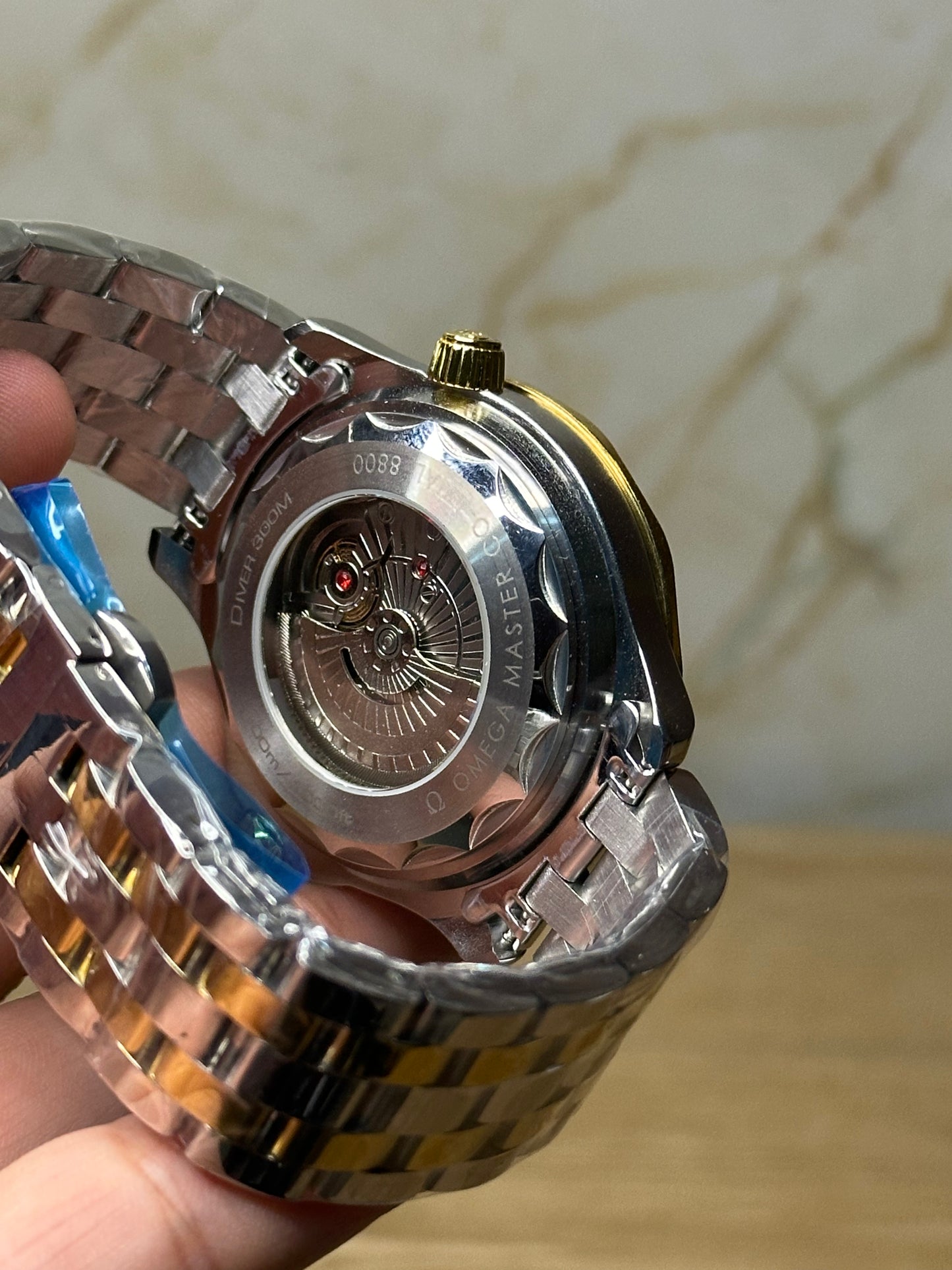 Omega Seamaster Diver AUTOMATICO fondo beige bisel dorado pulsera metalica