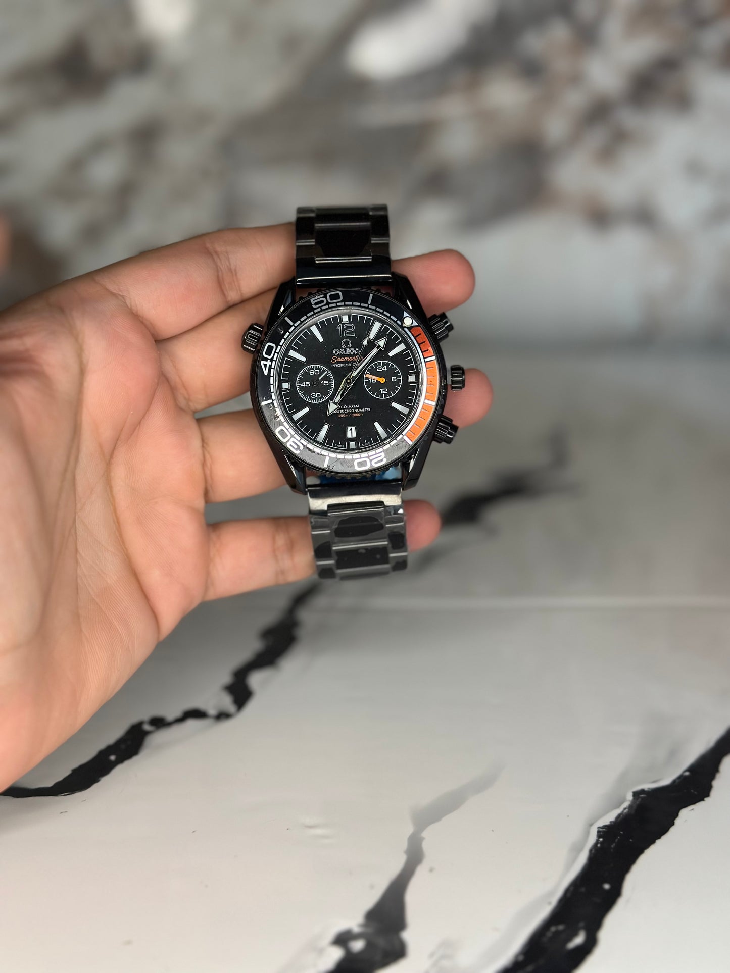 Reloj omega fondo negro bisel negro pulsera metálica cronógrafo