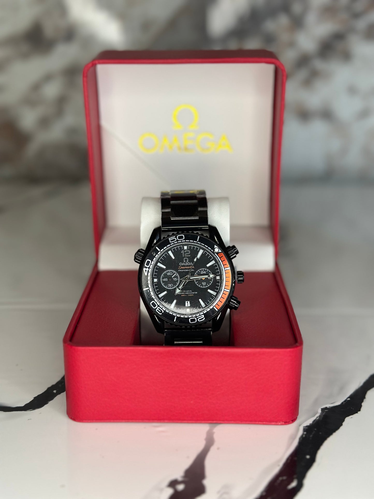 Reloj omega fondo negro bisel negro pulsera metálica cronógrafo