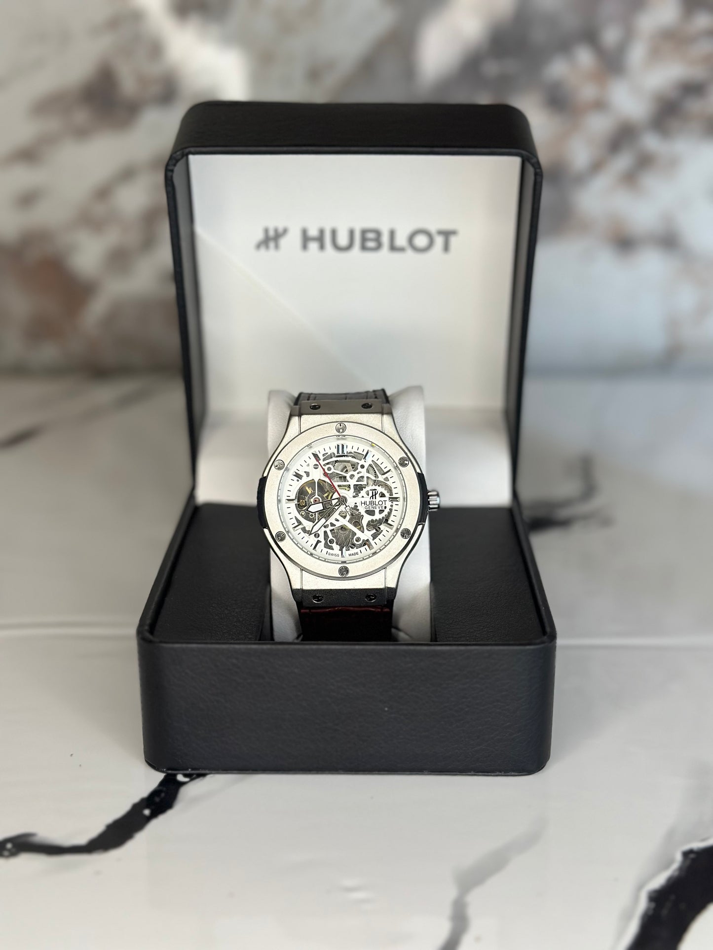 Reloj hublot automático corazón abierto fondo blanco bisel plateado pulsera de cuero