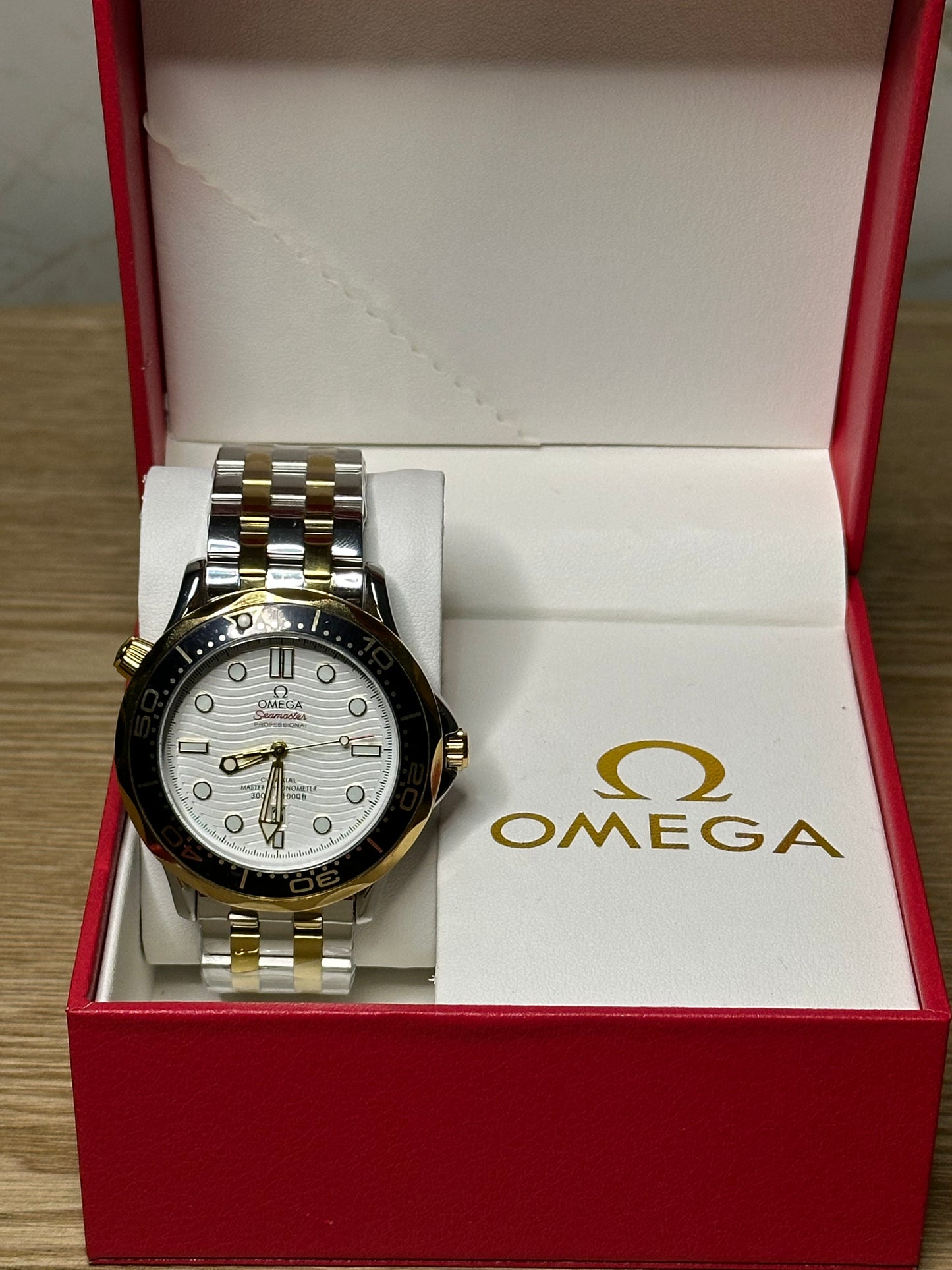 Omega Seamaster Diver AUTOMATICO fondo blanco bisel oscuro pulsera metalica