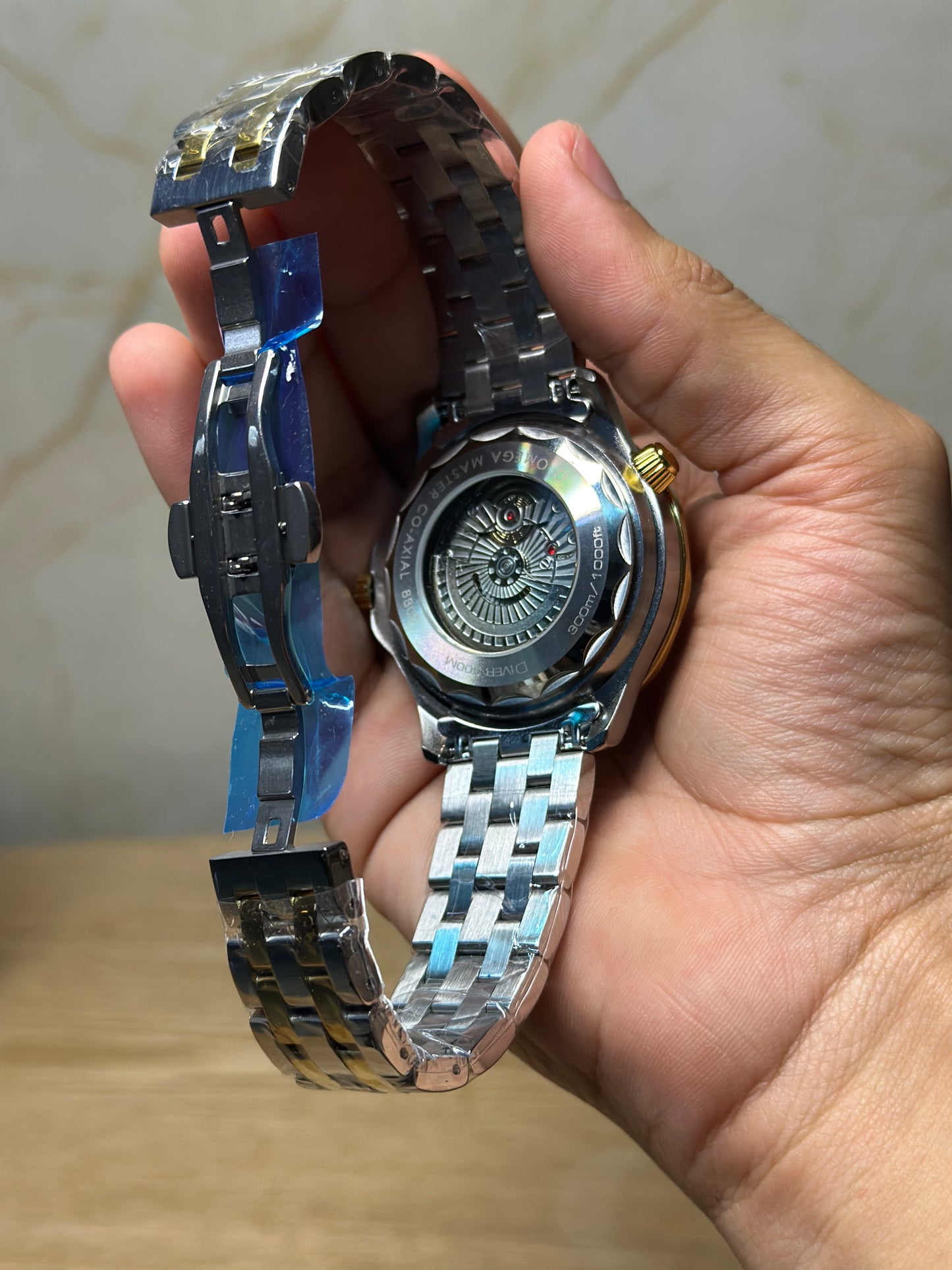Omega Seamaster Diver AUTOMATICO fondo blanco bisel oscuro pulsera metalica