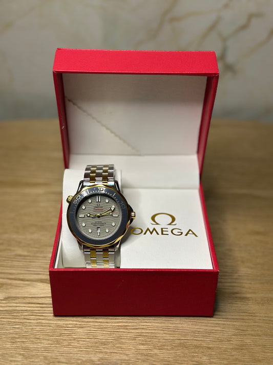 Omega Seamaster Diver AUTOMATICO fondo beige bisel dorado pulsera metalica